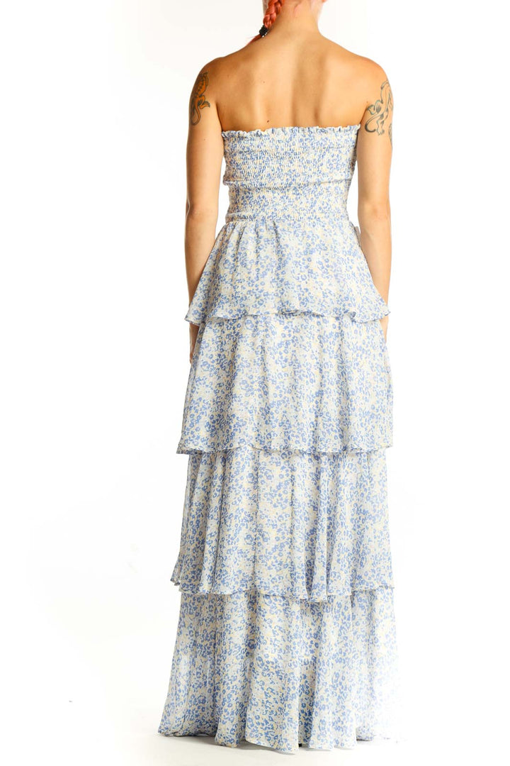 Side view of fab'rik blue floral tiered strapless maxi dress showing flowing tiers