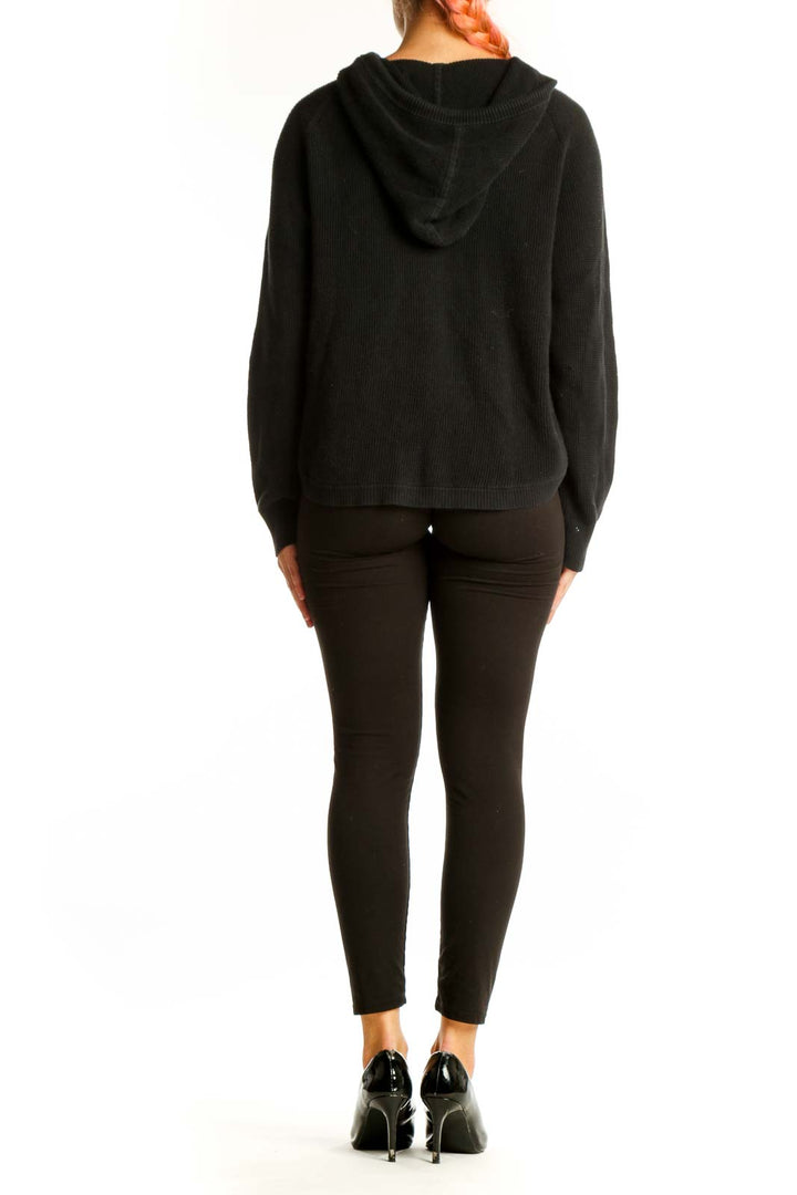 Side view of woman wearing black cotton knit hoodie sweater by Lauren Ralph Lauren
