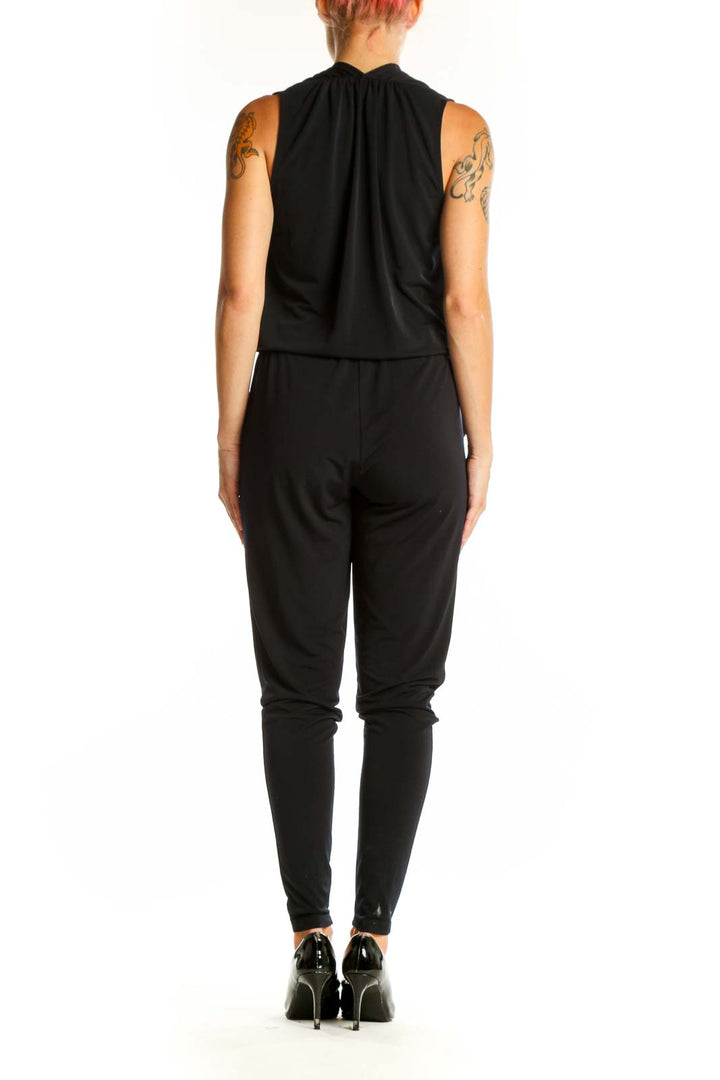 Side view of black MICHAEL Michael Kors jumpsuit showing tapered legs and sleeveless design