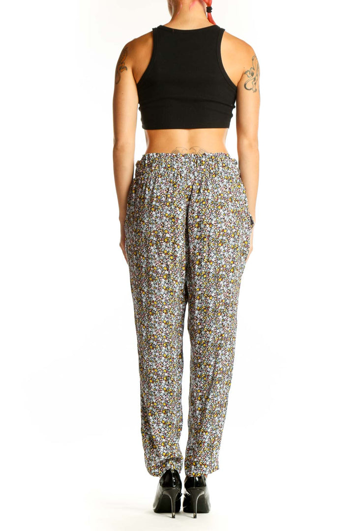 Side view of model wearing LOFT floral viscose pants with black crop top