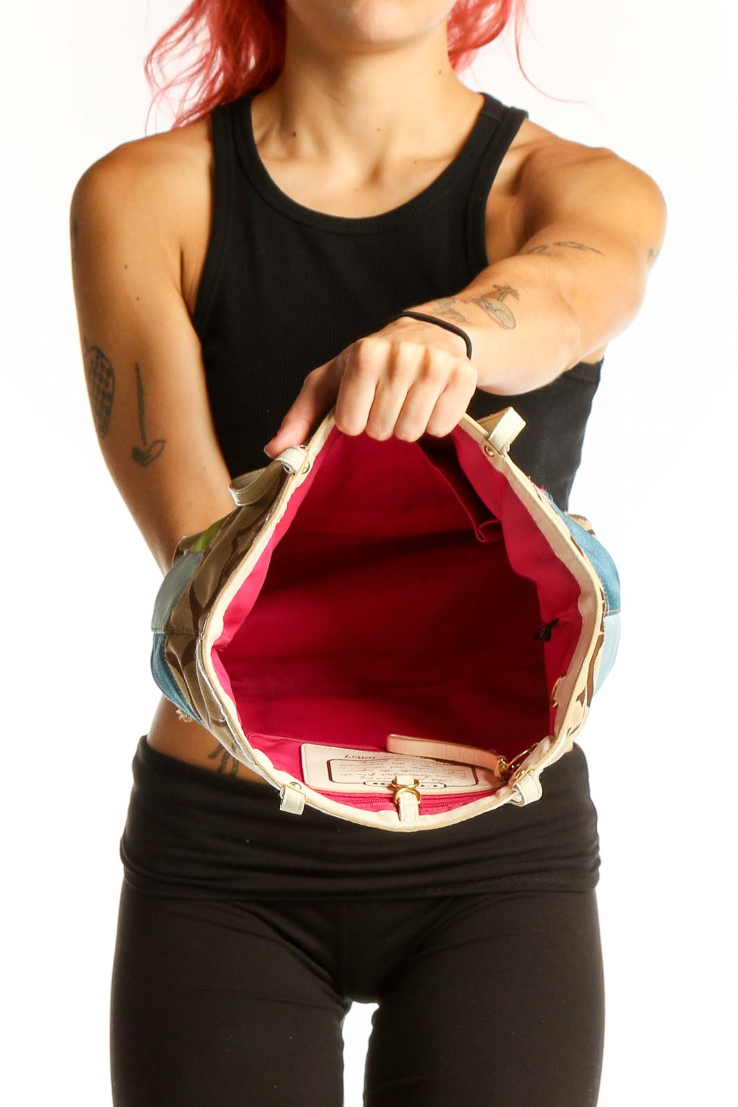 Side view of Coach beige shoulder bag worn by model