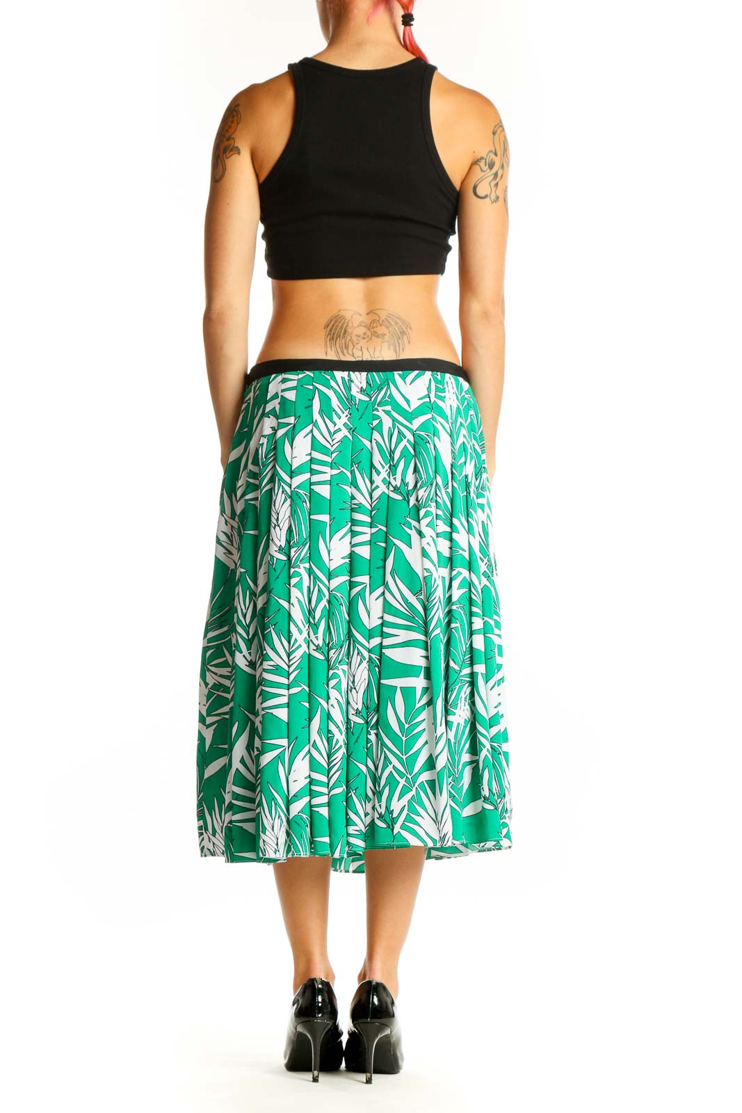 Side view of model wearing green tropical print pleated midi skirt from Talbots with black top