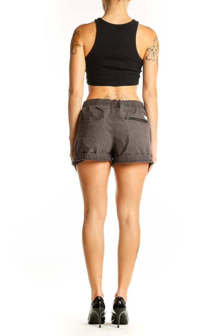 Side view of gray Vuori drawstring shorts on model with black crop top