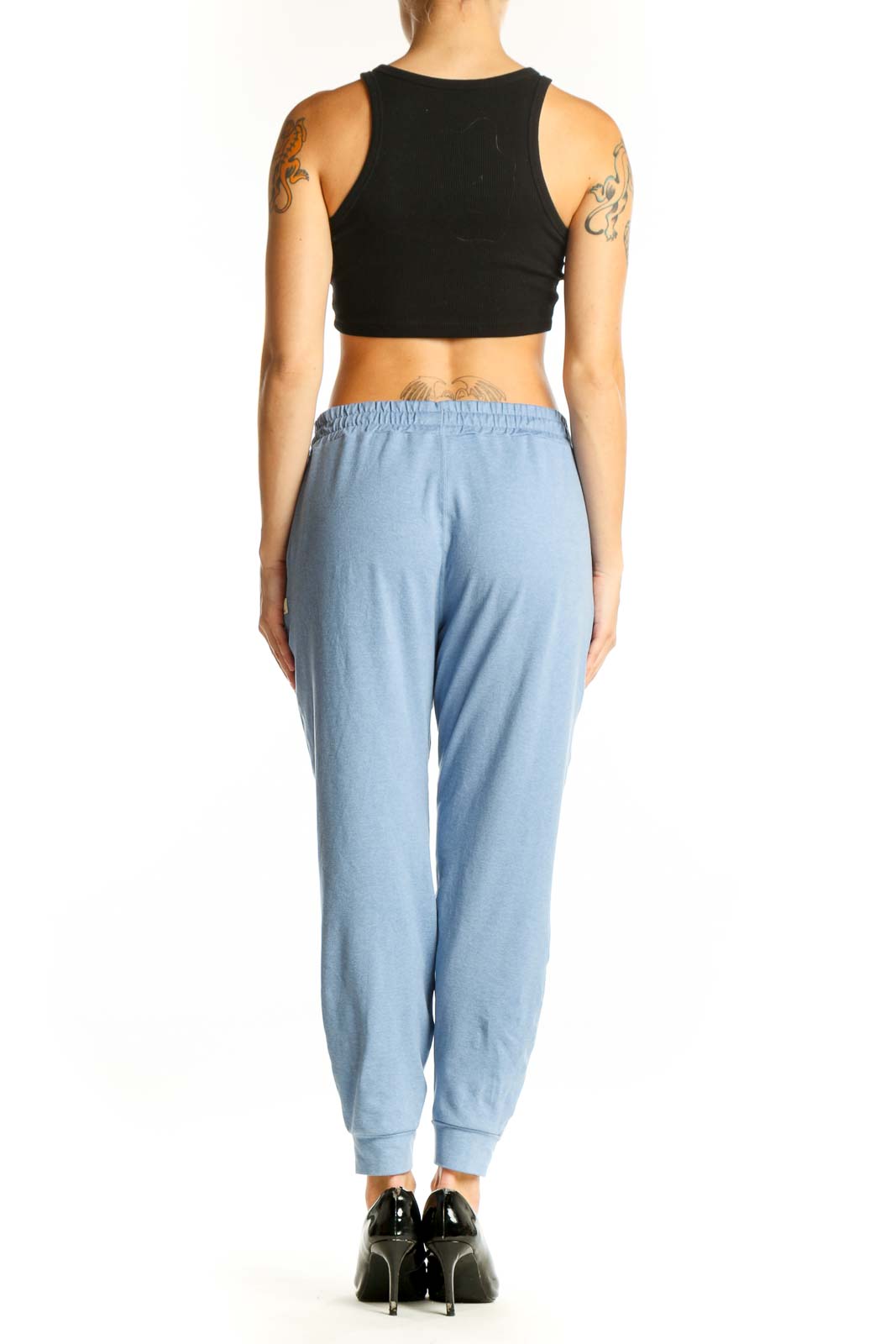Side view of light blue Vuori jogger pants on model with black crop top