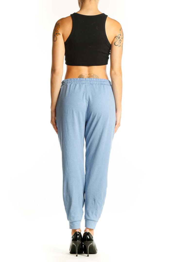 Side view of light blue Vuori jogger pants on model with black crop top
