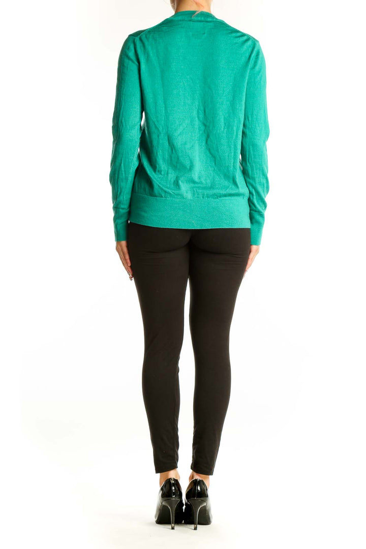 Side view of green Gap wool crewneck sweater on model with black pants