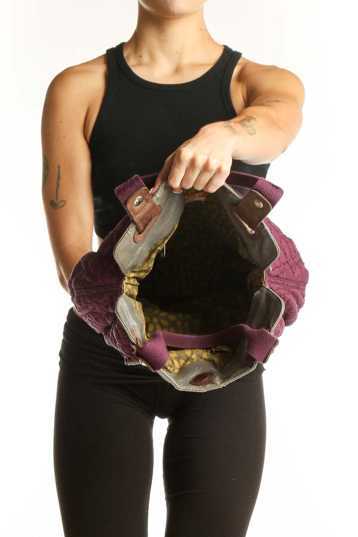 Side view of purple quilted Fossil messenger bag worn by model