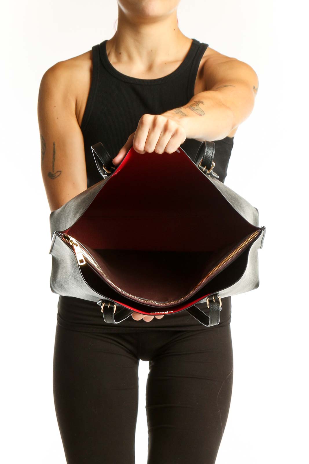 Side view of black leather Coach tote bag worn by model