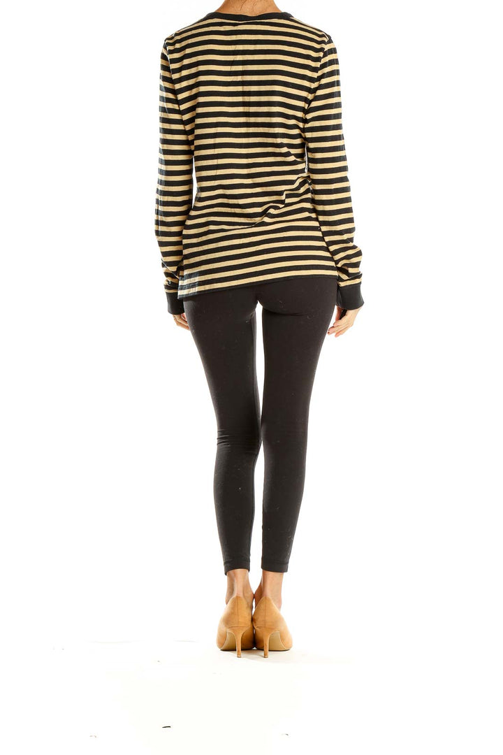 Side view of model wearing Patagonia black and tan striped long sleeve knit top with black leggings