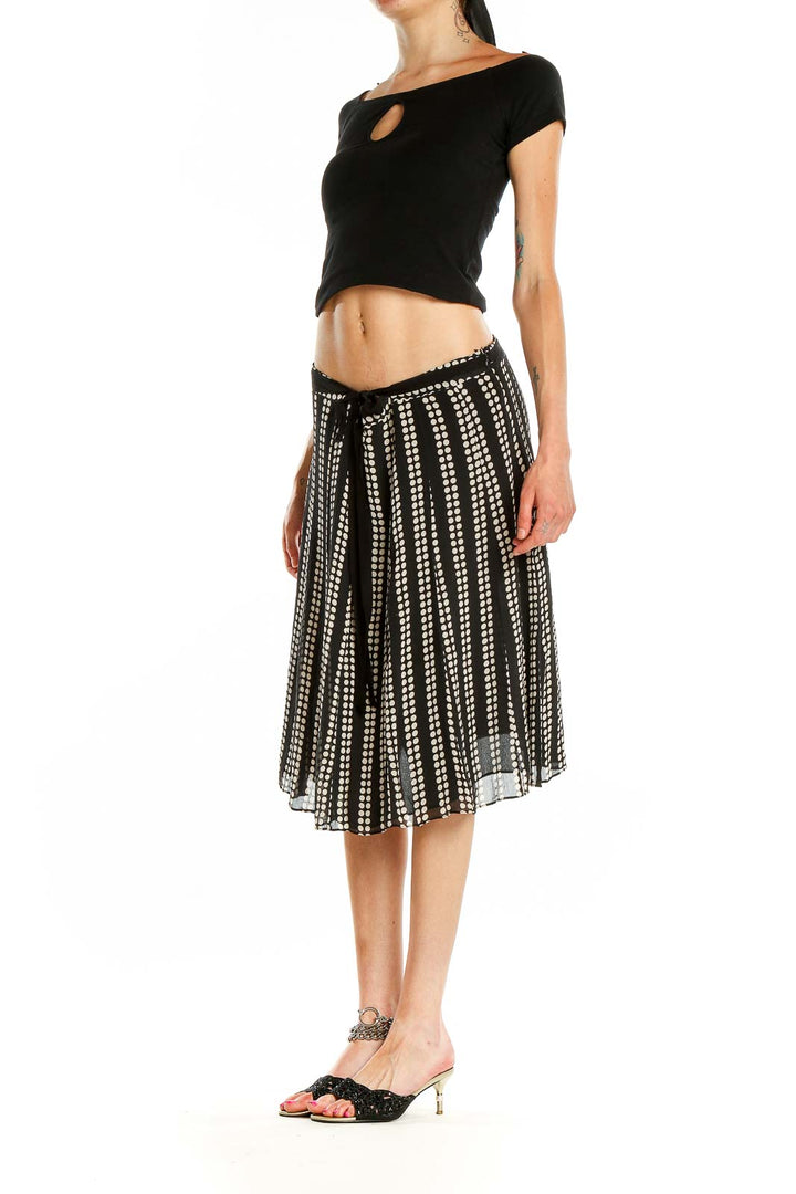 Front view of black and white polka dot pleated midi skirt by Uniform / John Paul Richard