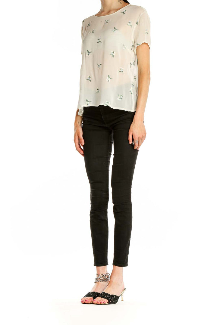 Front view of Laura Ashley cream blouse with green floral print and short sleeves