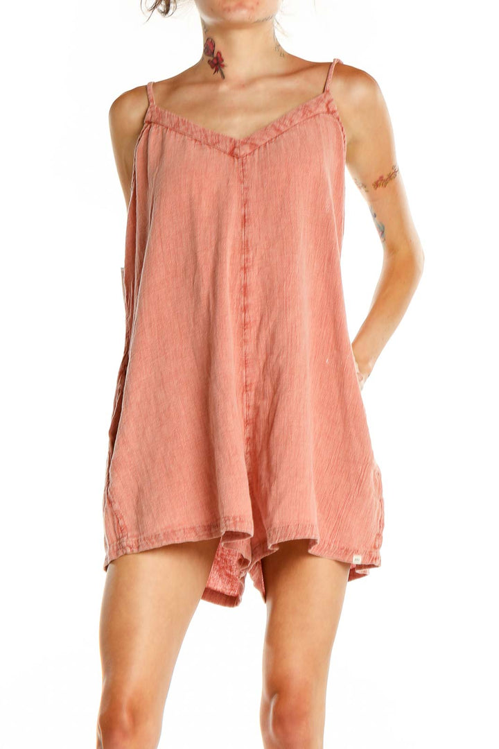 Front view of coral Ripcurl romper with spaghetti straps