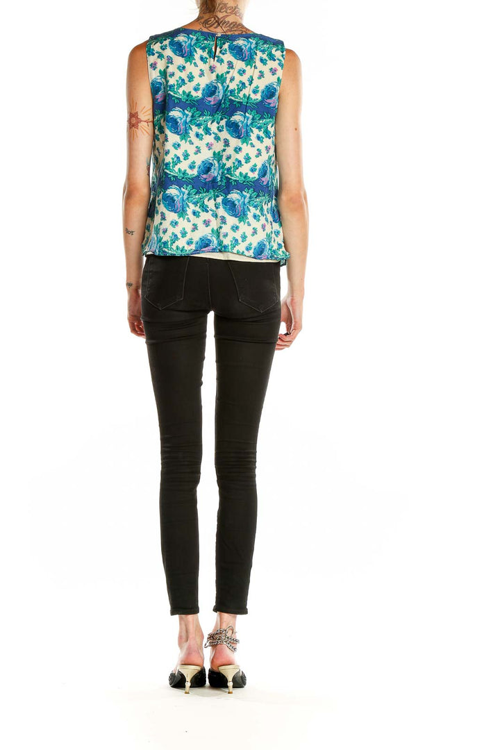 Side view of model wearing Talbots blue floral sleeveless blouse with black pants