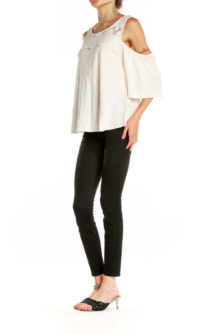 Front view of Sanctuary white lace cold shoulder blouse with fluttery sleeves