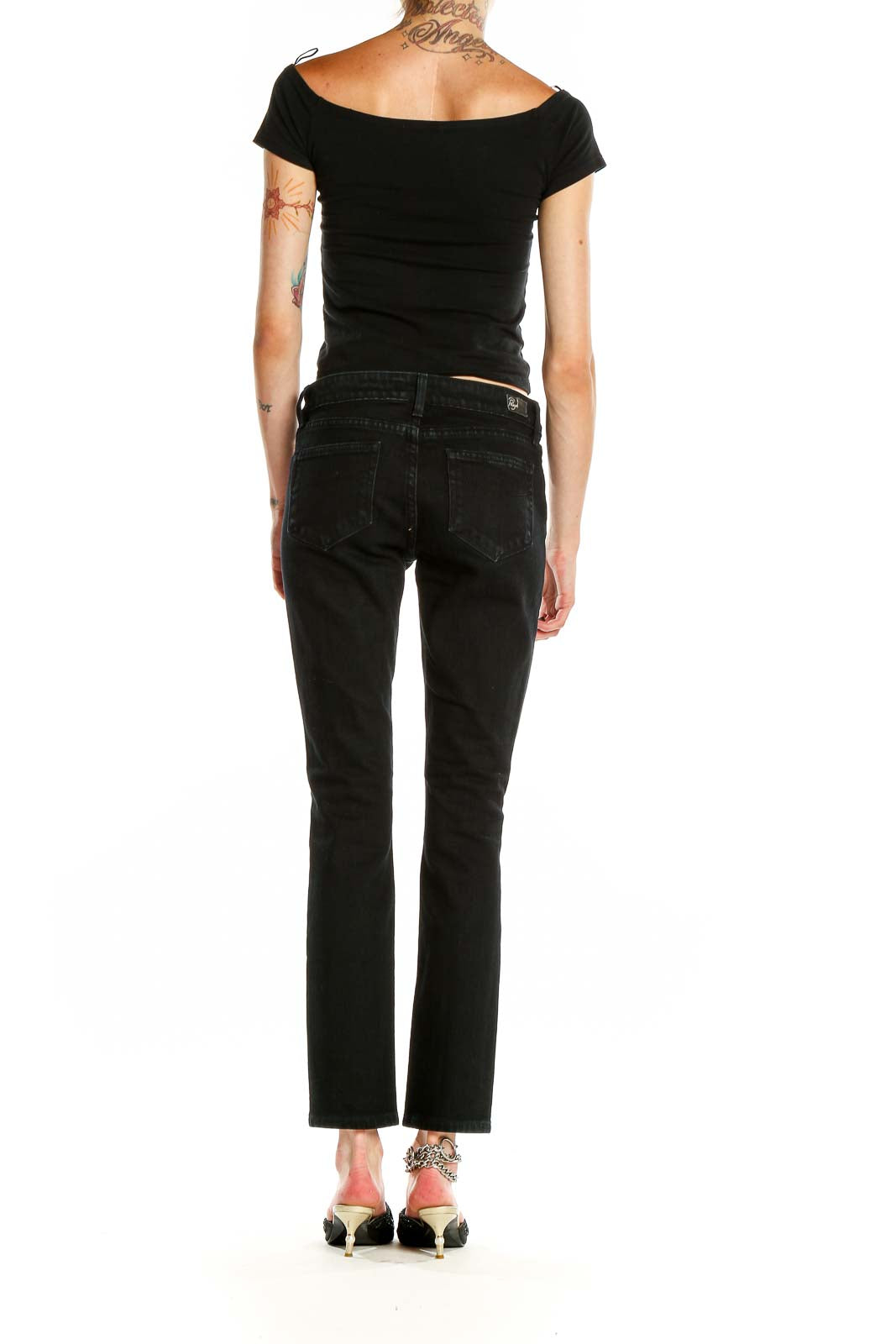 Side view of model wearing Paige black distressed straight leg jeans