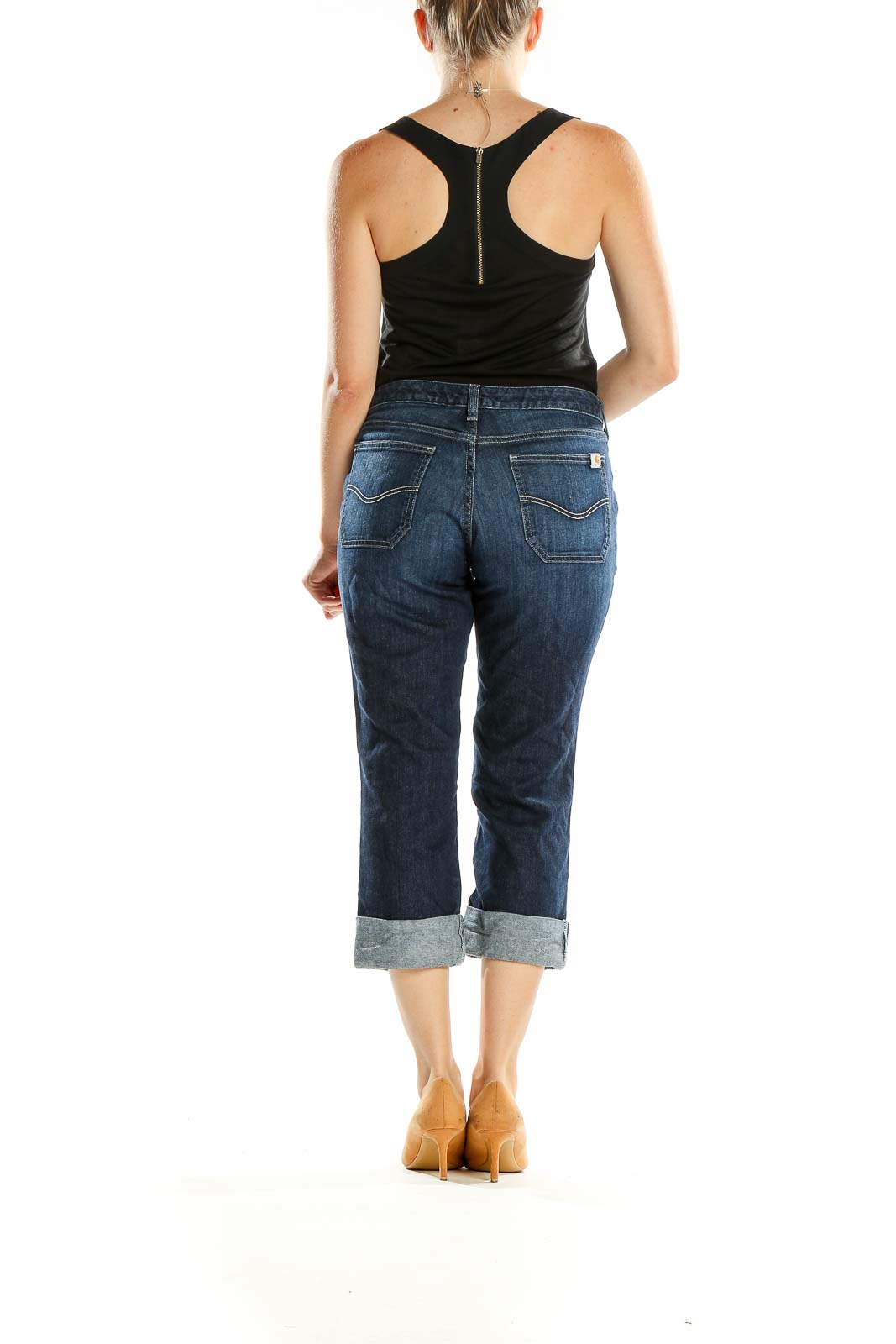Back view of Carhartt dark blue cuffed capri jeans on model