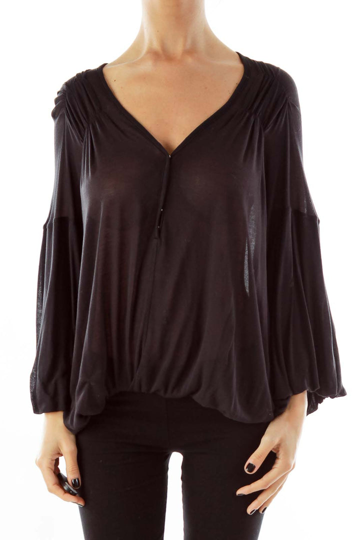 Front view of black Free People flowy top with V-neck and bell sleeves