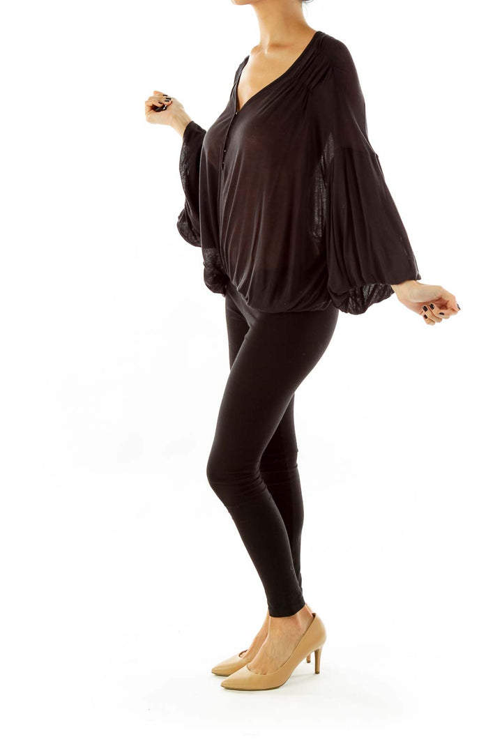 Front view of black Free People flowy top with V-neck and bell sleeves