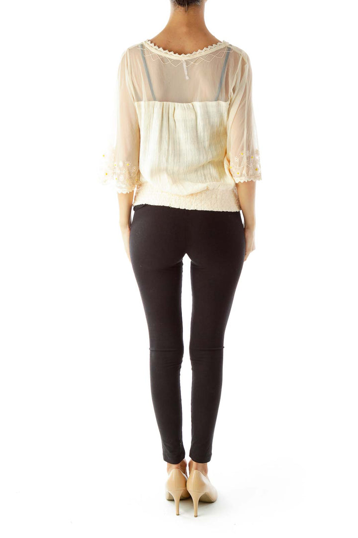 Back view of cream sheer peasant top showing gathered waistband and flowing silhouette