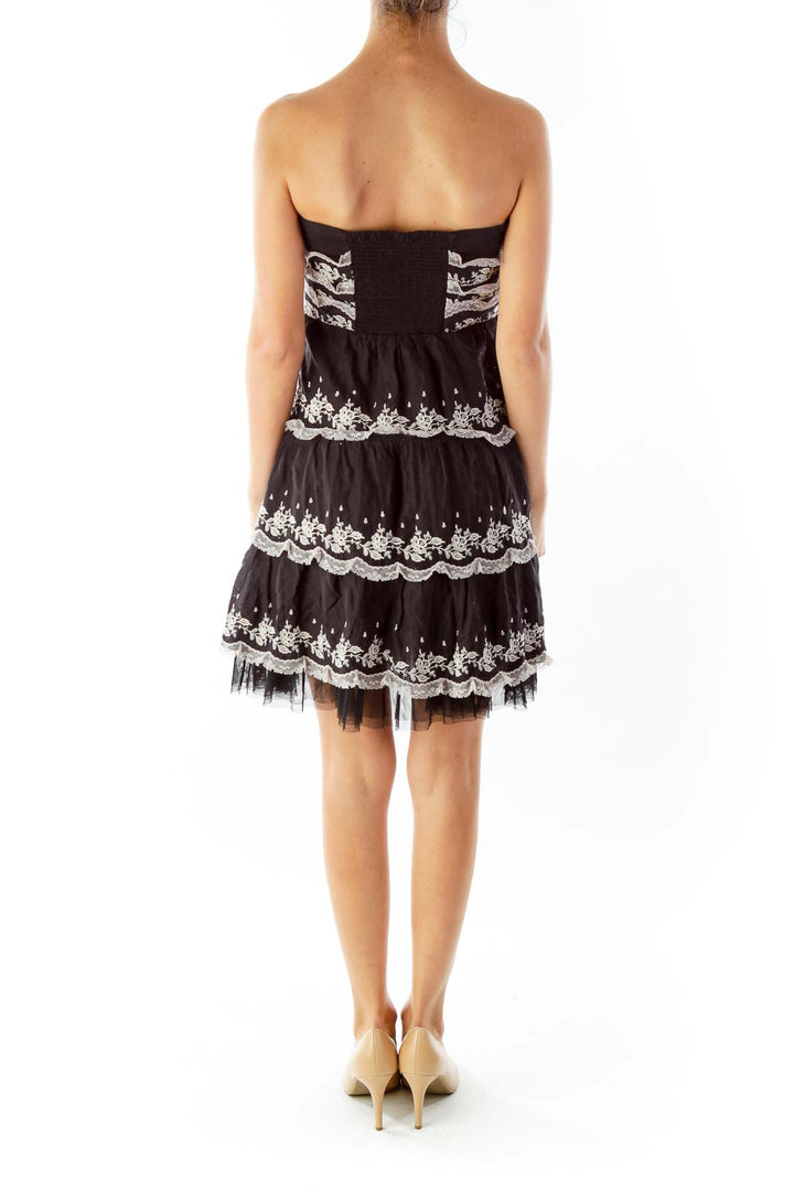 Back view of Free People black lace tiered strapless mini dress showing fitted bodice and tiered skirt