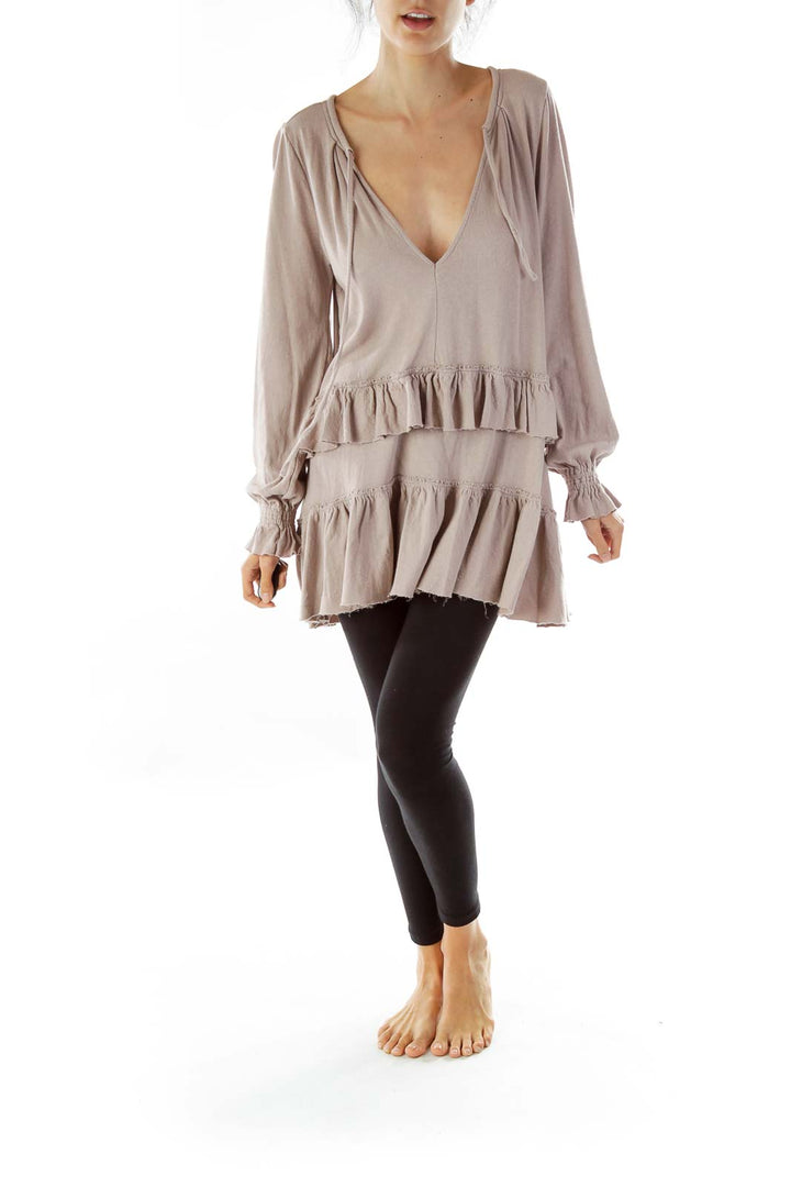 Front view of taupe Free People ruffled tunic top with V-neck and tiered ruffles