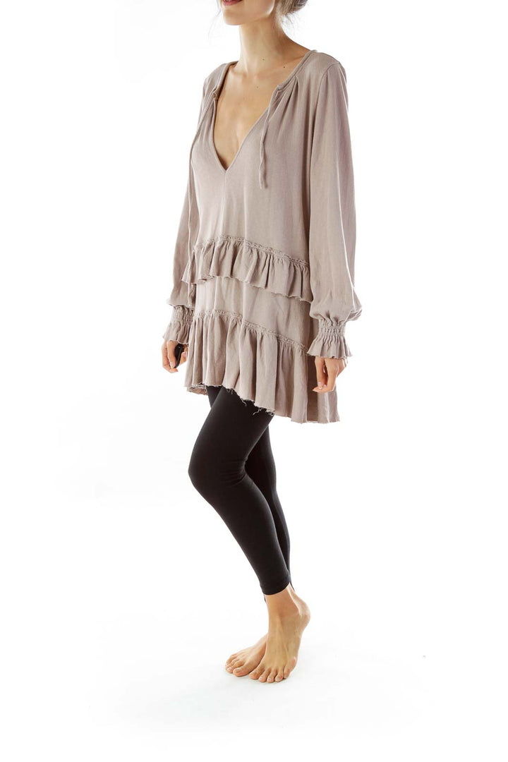 Front view of taupe Free People ruffled tunic top with V-neck and tiered ruffles