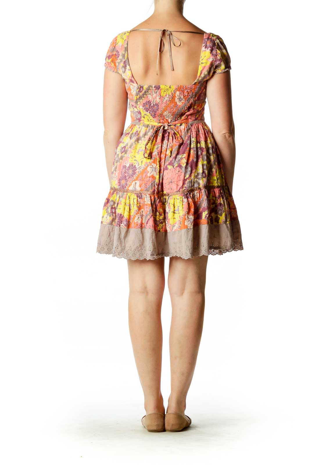 Back view of multicolor floral Free People babydoll mini dress with open back and tie closure