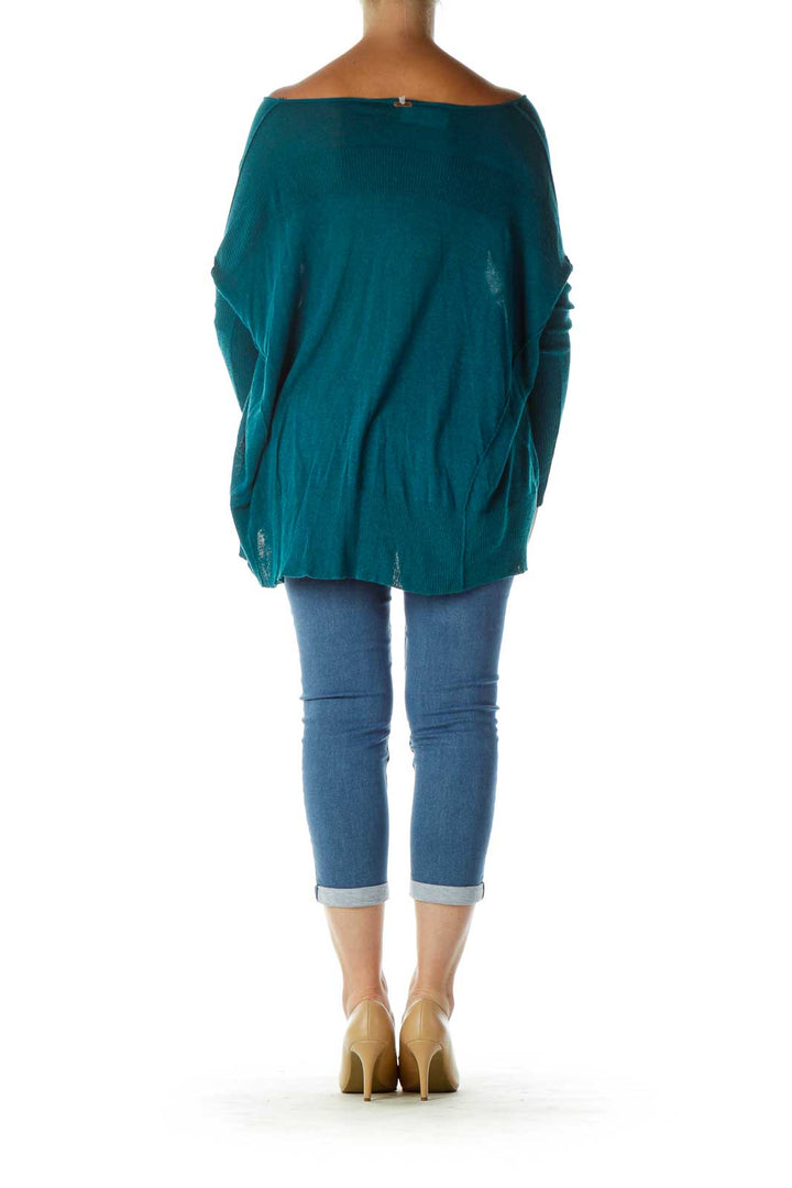 Back view of teal oversized V-neck knit sweater from Free People showing high-low hemline