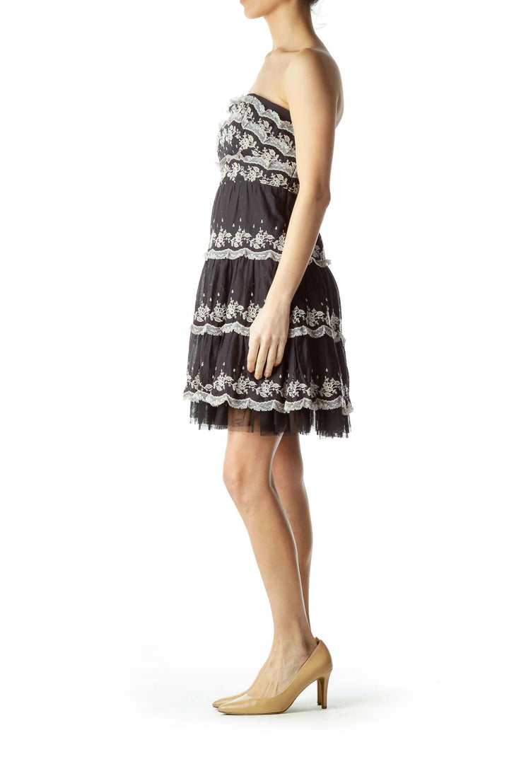 Front view of black strapless lace tiered dress by Free People