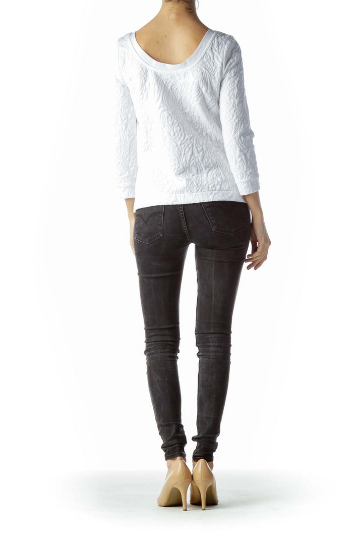 Back view of white textured Free People long sleeve top on model with dark jeans