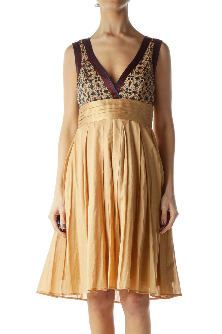 Front view of gold Catherine Malandrino cocktail dress with patterned bodice and pleated skirt