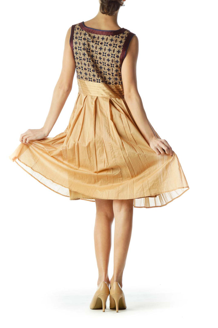 Back view of gold Catherine Malandrino cocktail dress showing patterned bodice and pleated skirt