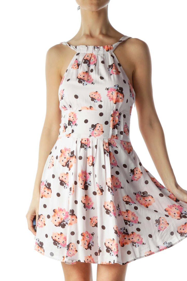 Front view of white halter dress with coral floral and brown polka dot print