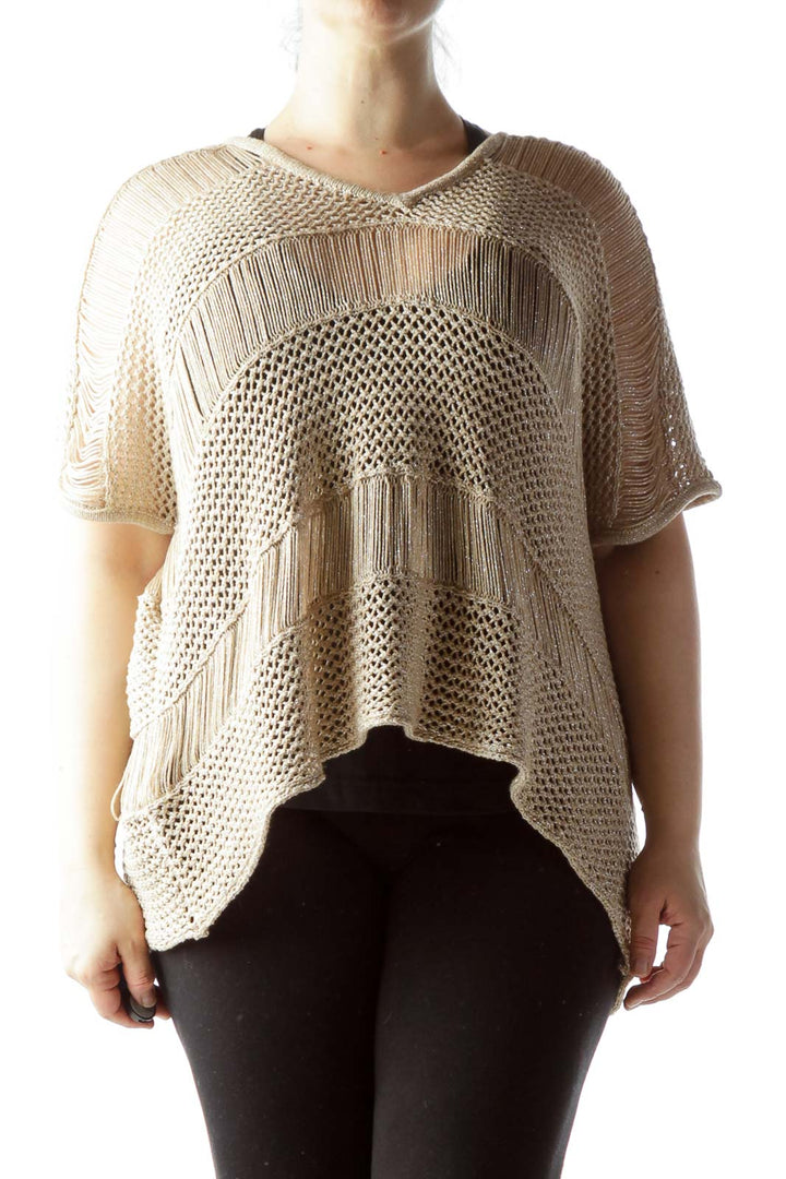 Front view of beige knitted poncho top with fringe details