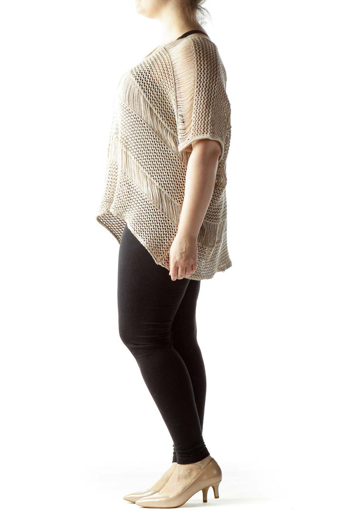 Front view of beige knitted poncho top with fringe details