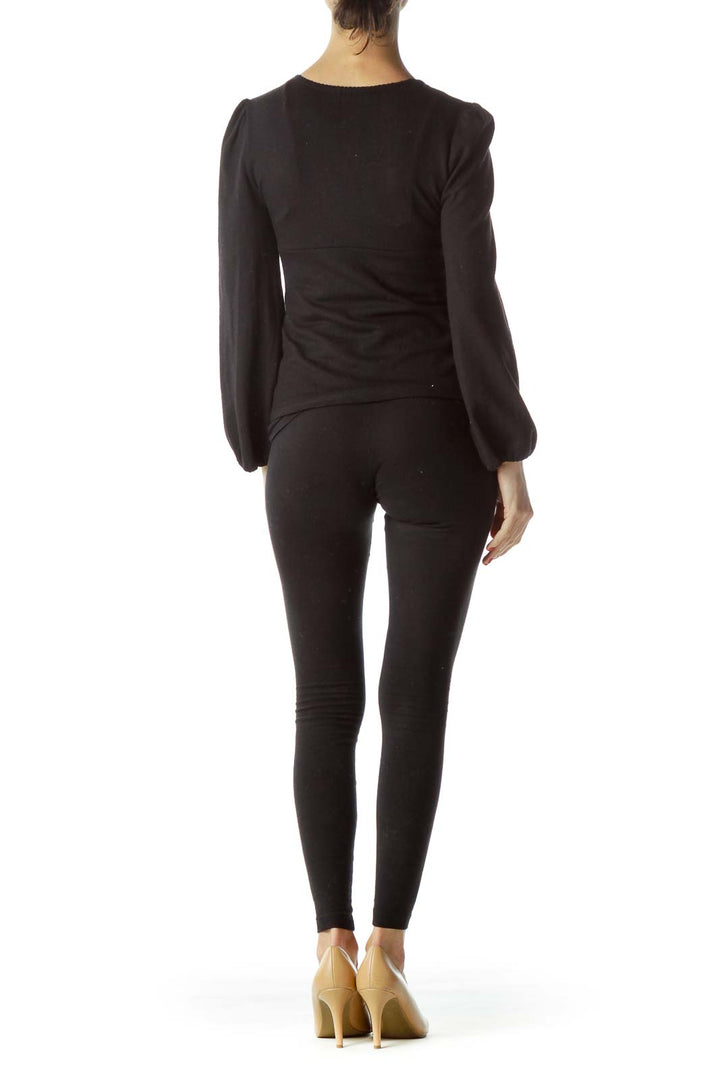 Back view of Erica Tanov black long-sleeve knit top showing fitted silhouette