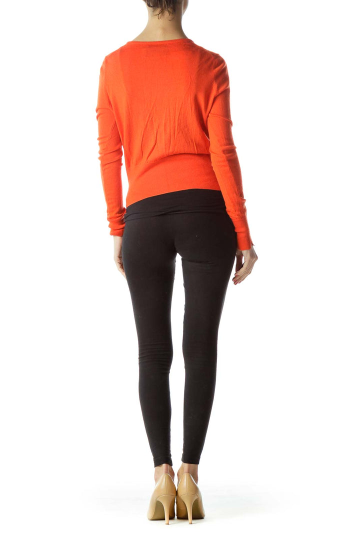 Back view of C. Wonder orange cropped cardigan on model with black pants