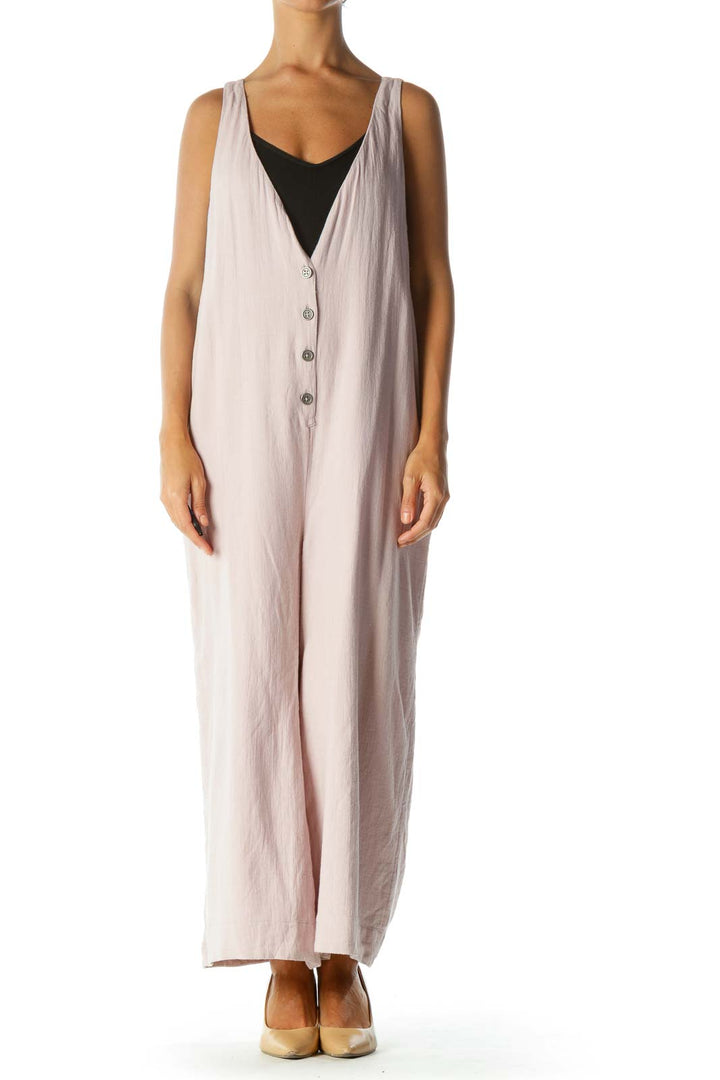 Front view of Free People blush pink sleeveless jumpsuit with button-front closure