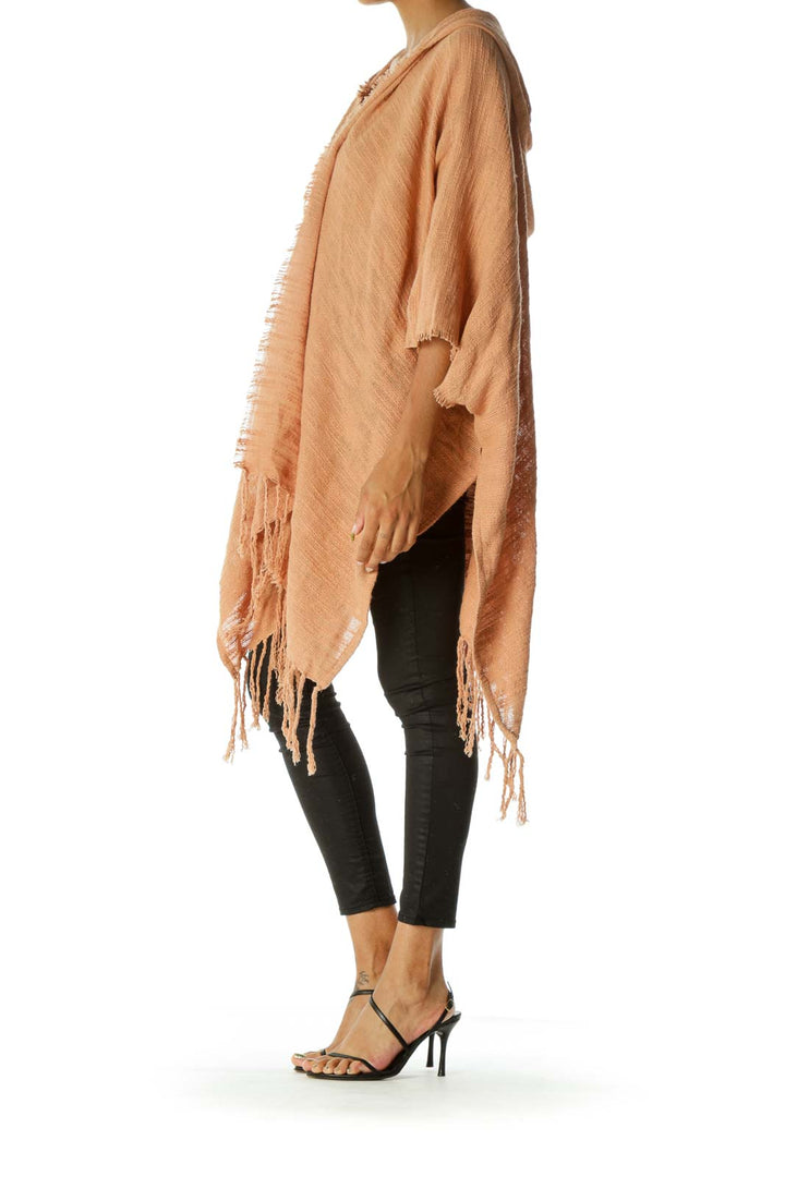 Front view of peach Free People fringed hooded poncho on model