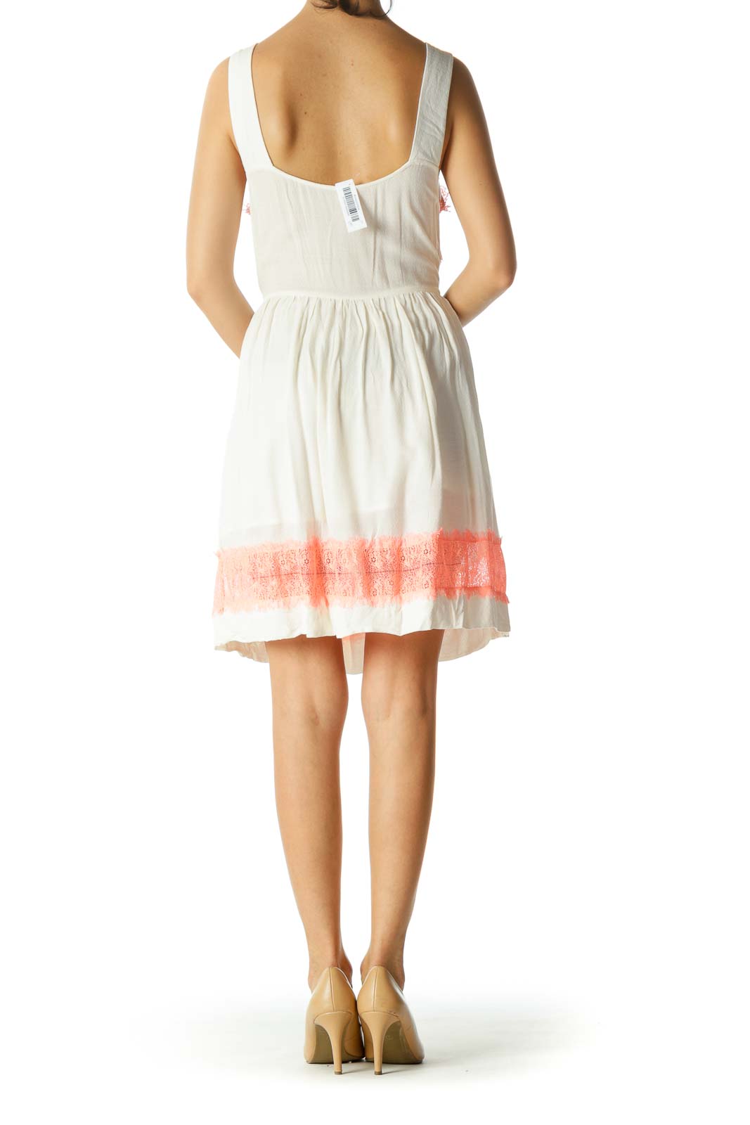 Back view of white Free People sundress showing button closure and coral lace hem