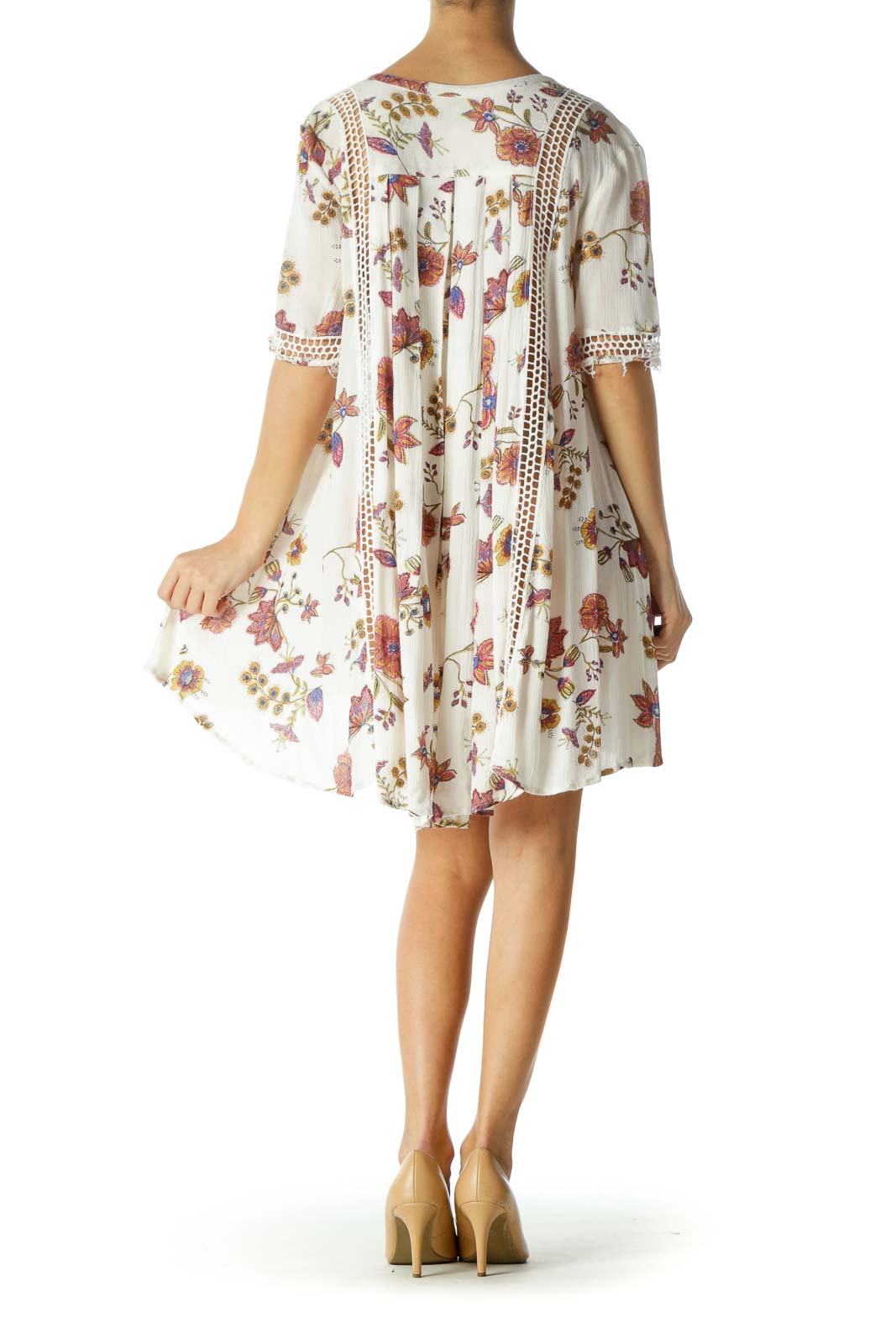 Back view of white floral Free People mini dress showing high-low hemline and flowy silhouette