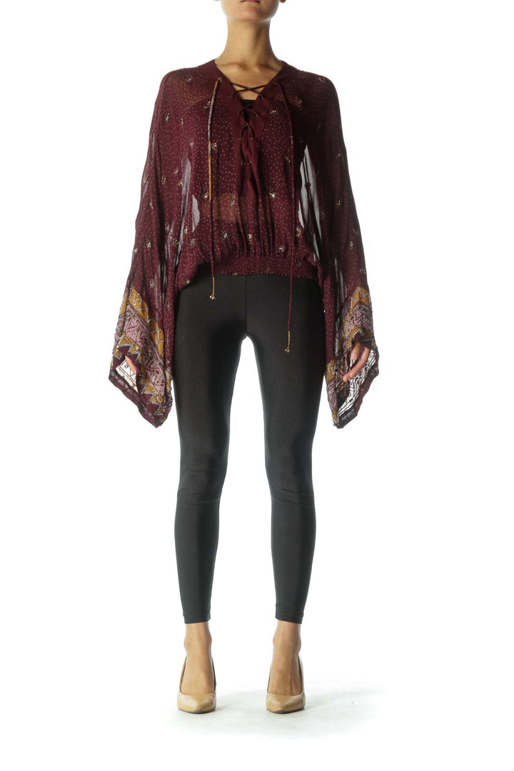 Front view of burgundy Free People top with lace-up neckline and bell sleeves