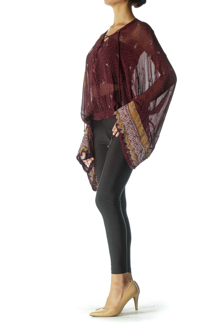 Front view of burgundy Free People top with lace-up neckline and bell sleeves