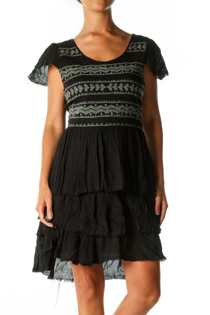 Front view of black Free People mini dress with geometric pattern and tiered skirt