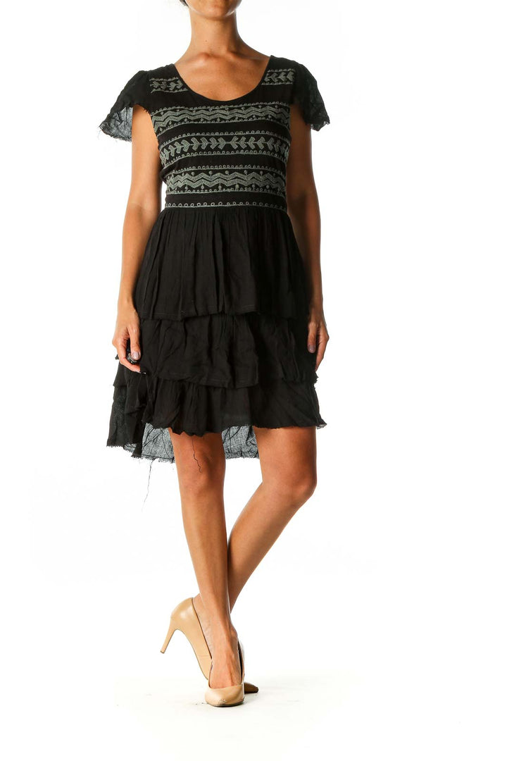 Front view of black Free People mini dress with geometric pattern and tiered skirt