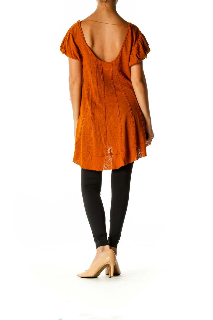 Back view of orange Free People tunic top showing high-low hemline and gathered sleeves