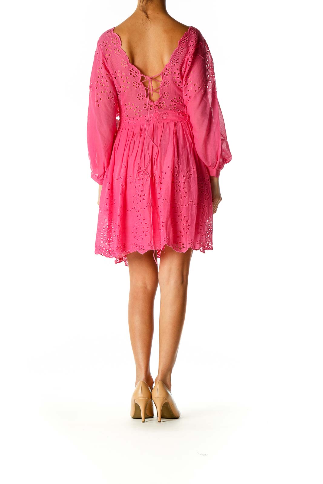 Back view of Free People pink eyelet lace mini dress showing V-back with tie closure