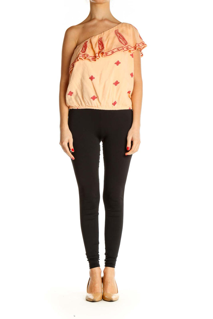 Front view of Free People peach one-shoulder top with red paisley embroidery and ruffled neckline