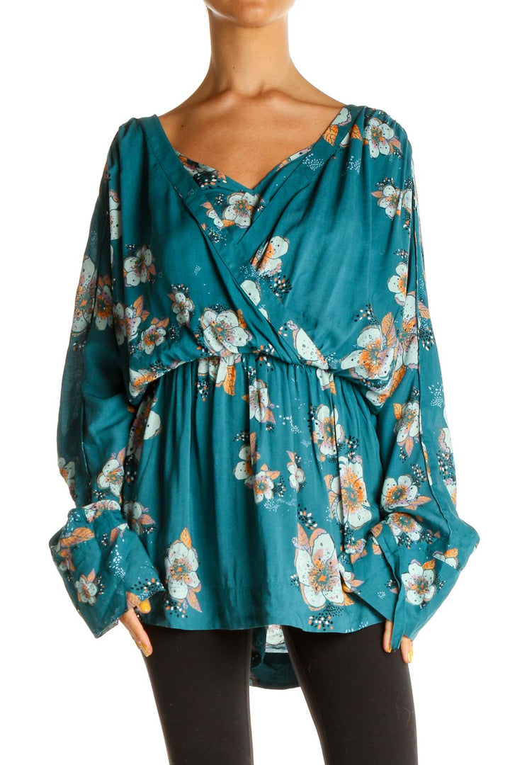 Front view of Free People teal floral wrap blouse with V-neckline and long sleeves