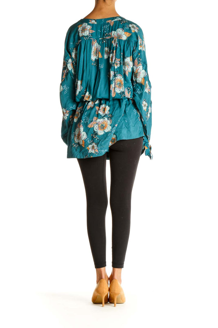 Back view of Free People teal floral wrap blouse showing gathered detail and flowy fit